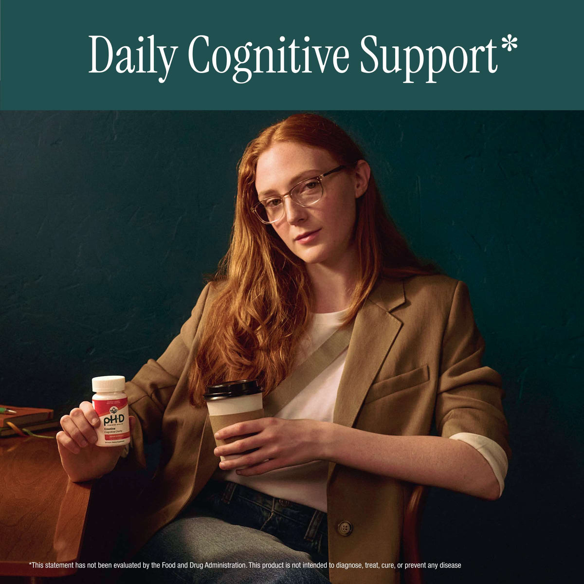 A woman with red hair and glasses sits holding a bottle of pH-D Creatine Cognitive Clarity against a dark teal background, with the text 'Daily Cognitive Support*' at the top.