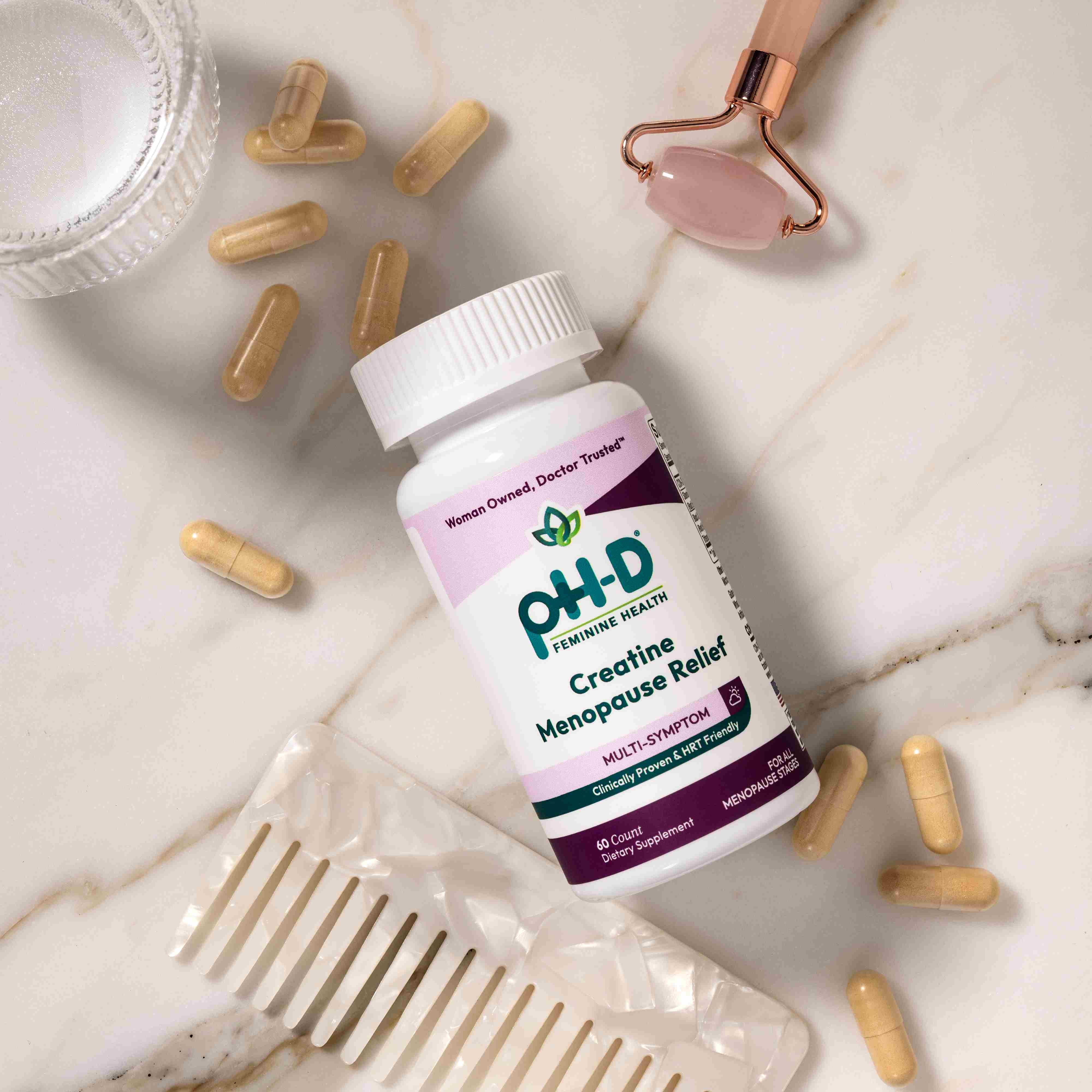 pH-D Feminine Health supplement bottle with capsules on a marble surface
