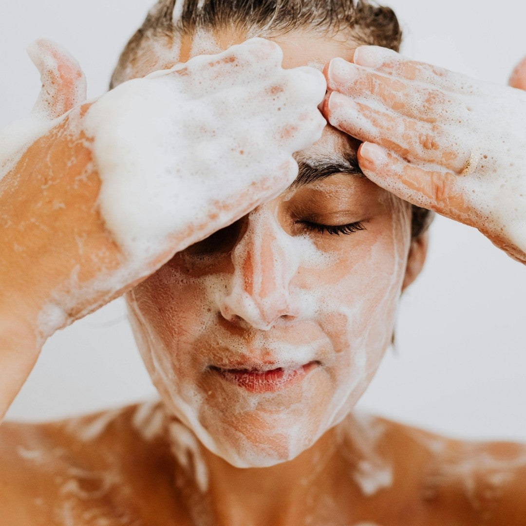 Woman washing her face in the shower