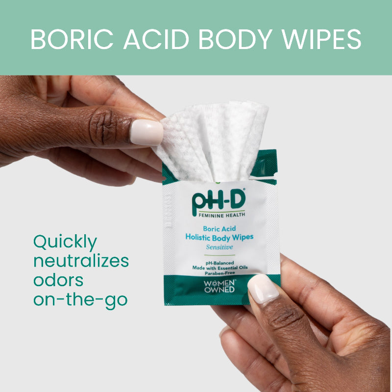 PH-D Boric Acid Body Wipes being held by a hand with a green background
