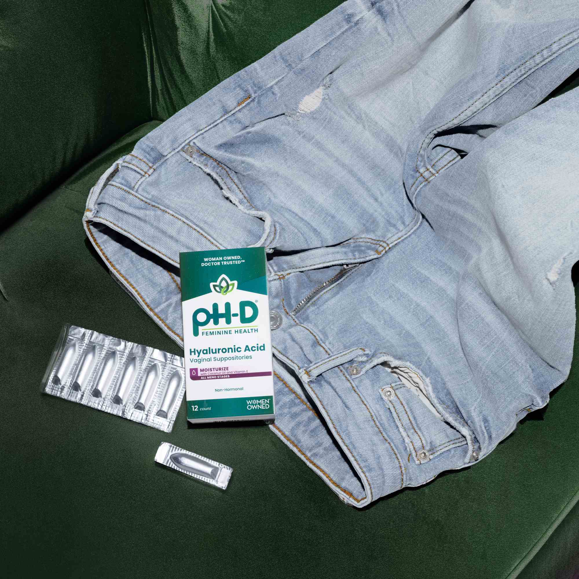 pH-D Feminine Health hyaluronic acid vaginal suppository sitting on a pair of jeans on a green couch