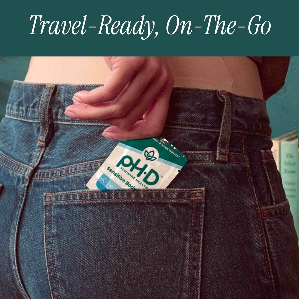 A close-up of a person's hand placing a pH-D Feminine Health Sensitive Body Wipe in their back pocket. 