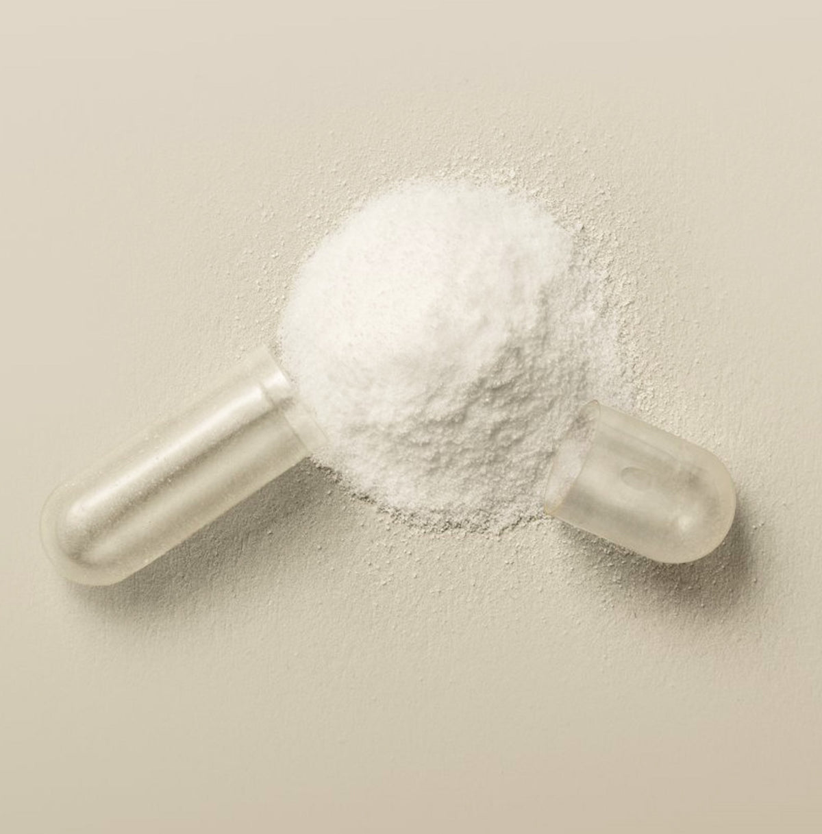 A clear plastic boric acid suppository filled with white powder, photographed on a plain warm beige background.