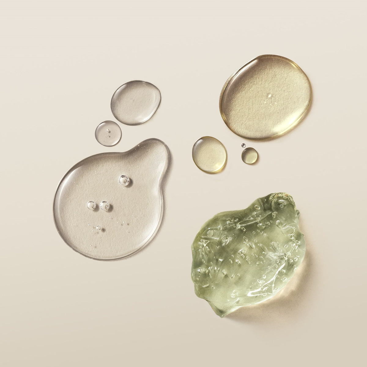 Two cosmetic textures on a warm beige background: a clear transparent gel drop on the left and a translucent light green gel swatch on the bottom right.